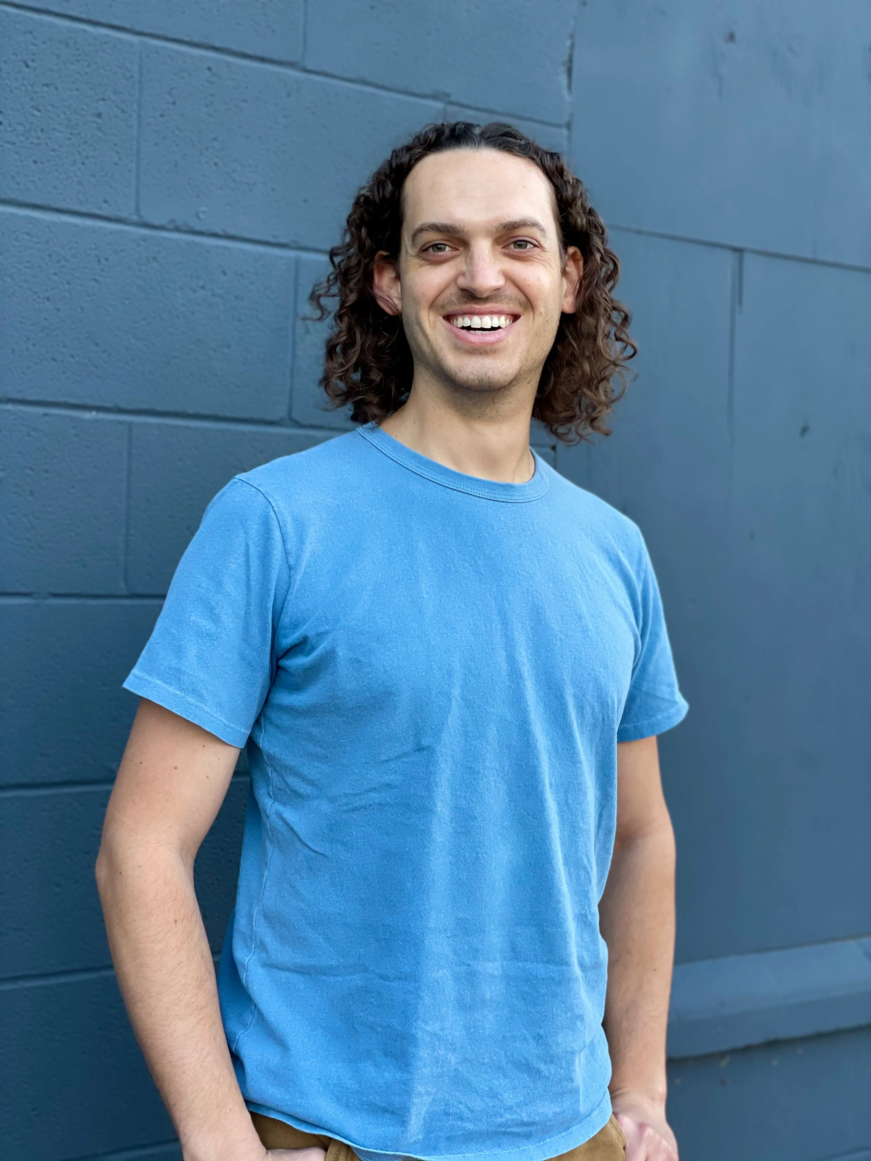 Spencer smiling against a wall